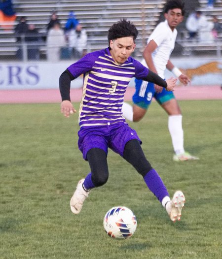Lemoore's Zaid Bueno has his eyes on the ball as he attempts to get past Lompoc defenders. 